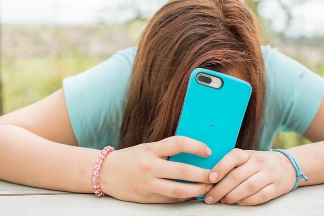 kid hiding under phone