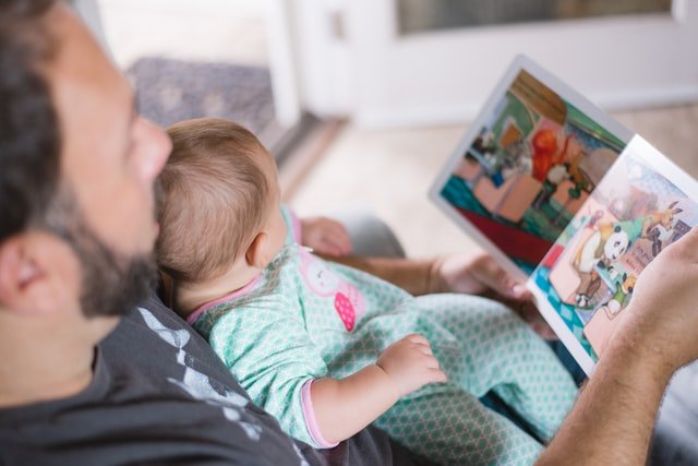 father and baby reading story book